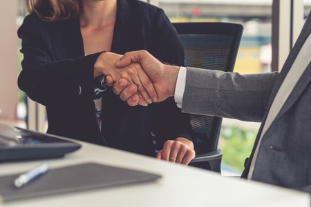 Businessman executive handshake with businesswoman worker in modern workplace office. People corporate business deals concept.の写真素材