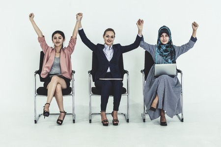 Happy young businesswomen group celebrating work success together. Workplace community and human resources concept.の写真素材