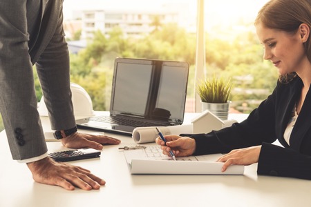 Architect and engineer working with construction drawing project on table in office. Architecture and engineering business concept.の写真素材
