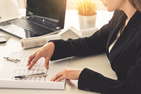 Architect and engineer working with construction drawing project on table in office.の写真素材