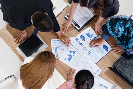 Top view of businessman executive in group meeting with other businessmen and businesswomen in modern office with laptop computer, coffee and document on table.の写真素材