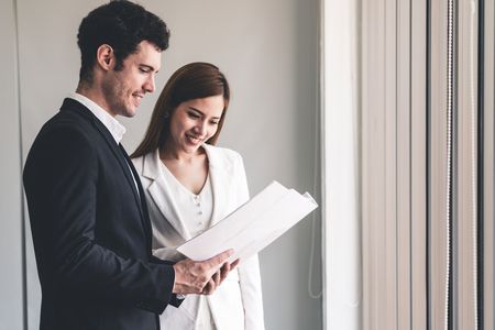 Businessman executive is in meeting discussion with businesswoman or client in modern workplace office.の写真素材