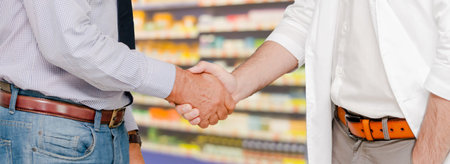 Doctor in hospital handshake with another doctor. Healthcare people teamwork and medical service concept.の写真素材