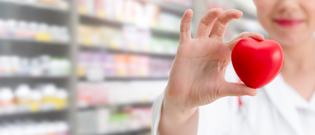 Doctor holding a red heart at hospital office. Medical health care and doctor staff service concept.の写真素材