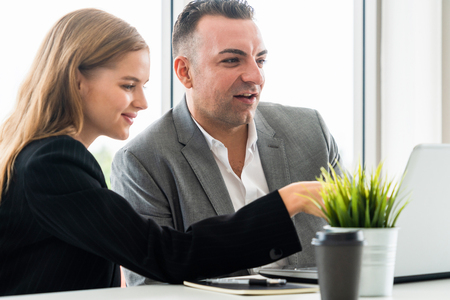 Businessman executive is in meeting discussion with a businesswoman worker in modern workplace office. People corporate business team concept.の写真素材