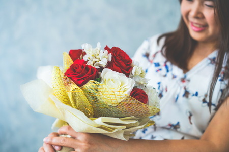 Happy woman gets rose bouquet gift from her boyfriend on Valentines day. Couple love lifestyle concept.の写真素材