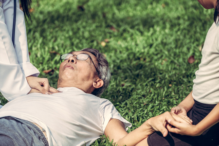 Senior man having chest pain or heart attack in the park. Old people elderly healthcare concept.の写真素材