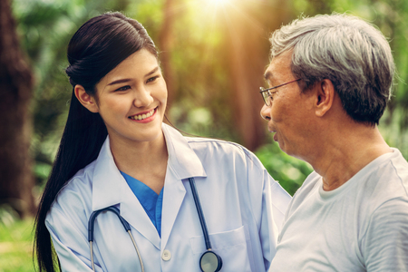 Friendly doctor taking care of senior man in the hospital garden. Medical and healthcare doctor service concept.の写真素材