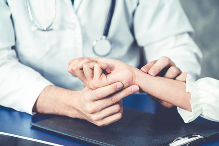 Young doctor examining female patient in hospital office. Medical healthcare and doctor staff service concept.の写真素材