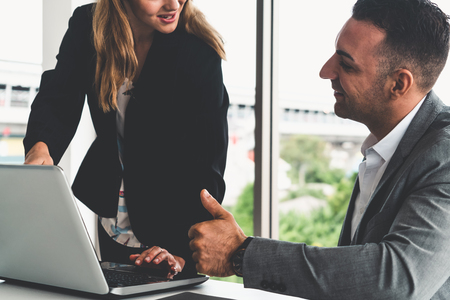 Businessman executive is in meeting discussion with a businesswoman worker in modern workplace office. People corporate business team concept.の写真素材