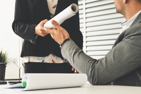 Businessman executive receive finished project from businesswoman worker in modern workplace office. People corporate business deals concept.の写真素材