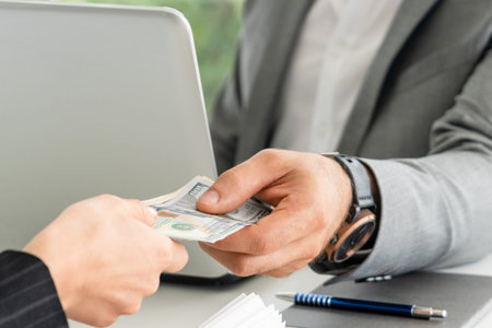 Businessman hand sending money to another business person. Transaction, payment, salary and banking...