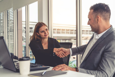 Businessman executive handshake with businesswoman worker in modern workplace office. People...