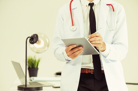 Doctor working on tablet computer at office in the hospital. Medical and healthcare concept.の写真素材
