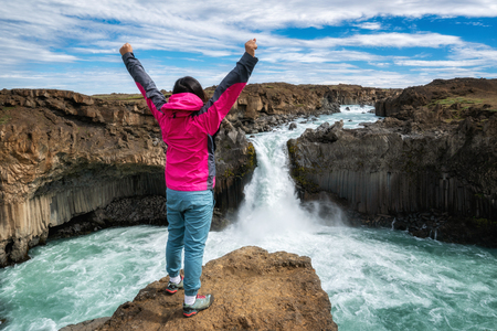 Traveler hiking in Icelandic summer landscape at the Aldeyjarfoss waterfall in north Iceland. The waterfall is situated in the northern part of the Sprengisandur Road within the Highlands of Iceland.の写真素材