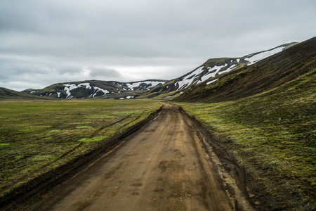 Beautiful Landmanalaugar gravel dust road way on highland of Iceland, Europe. Muddy tough terrain for extreme 4WD 4x4 vehicle. Landmanalaugar landscape is famous for nature trekking and hiking.の写真素材