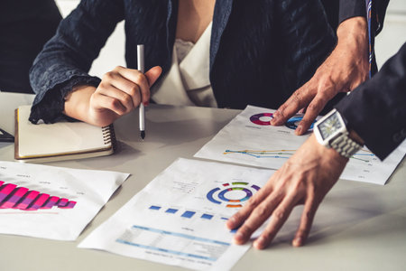 Businessman and businesswoman in  meeting working with many financial statement document on desk....