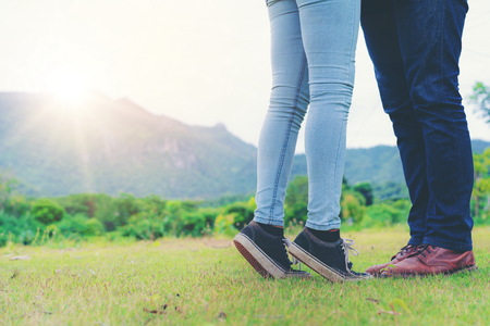 Happy couple take a romantic walk in green grass field on the hills. Travel and honeymoon concept.の写真素材
