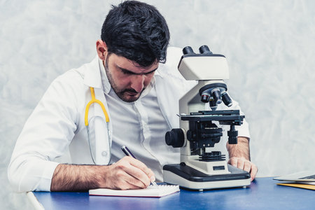 Young male doctor working using microscope in hospital laboratory. Medical and medicine technology...