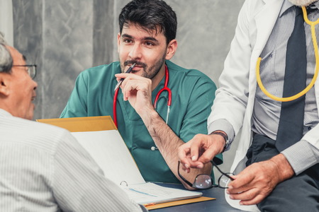 Male doctor team talking to senior patient visit at the hospital office. Medical healthcare staff service concept.の写真素材