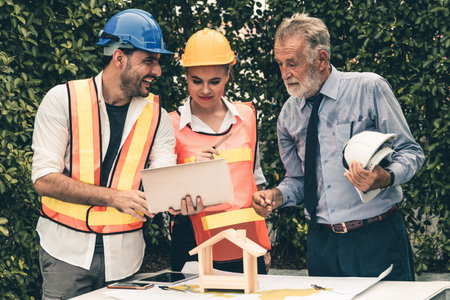 Engineer, architect and business man working on the engineering project at construction site. House...