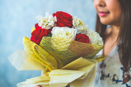 Happy woman gets rose bouquet gift from her boyfriend on Valentines day. Couple love lifestyle concept.の写真素材