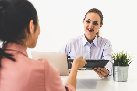 Two young business women in meeting at office table for job application and business agreement.の写真素材