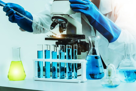Young woman scientist working in chemical laboratory and examining biochemistry lab sample.の写真素材