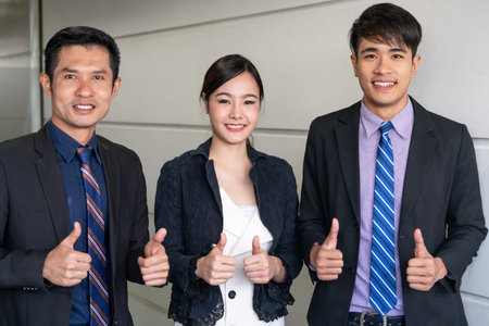 Many happy business people make thumbs up sign join hands together with joy and success.