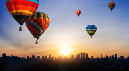 Beautiful panoramic urban cityscape in modern metropolis with colorful high hot air balloons festival in summer skyの写真素材