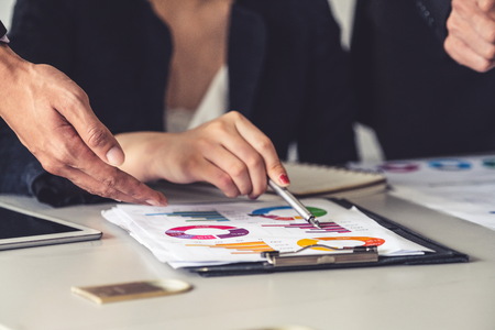 Businessman and businesswoman in  meeting working with many financial statement document on desk.の写真素材