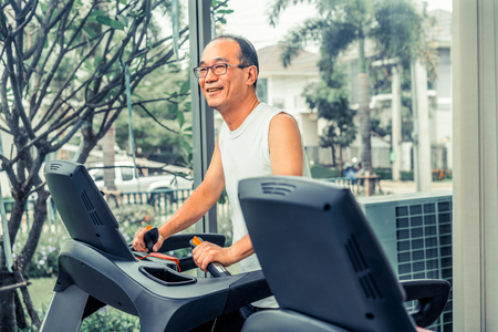 Senior man exercise on treadmill in fitness center. Mature healthy lifestyle.の写真素材