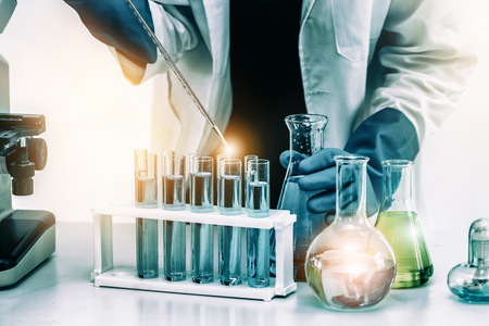 Young woman scientist working in chemical laboratory and examining biochemistry lab sample. Science technology medicine research and development study concept.の写真素材