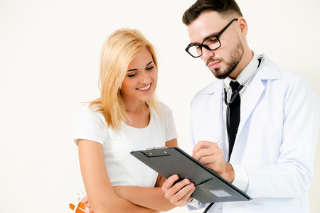 Male doctor and female patient with documents of patients health record are having conversation in hospital. Healthcare and medical service.の写真素材