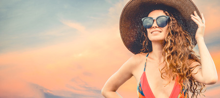 Beautiful young sexy woman in swimsuit posing on color background. Summer advertising.の写真素材