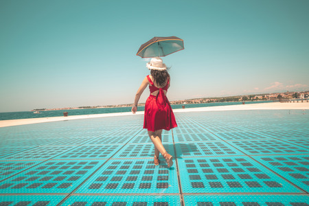 Happy woman traveler dances on outdoor disco floor in Zadar, Croatia.の写真素材