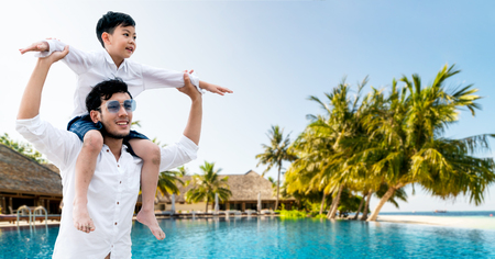 Happy father carrying his son on shoulders is on vacation and escape to nature.の写真素材