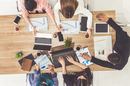 Top view of businessman executive in group meeting with other businessmen and businesswomen in modern office with laptop computer, coffee and document on table. People corporate business team concept.の写真素材