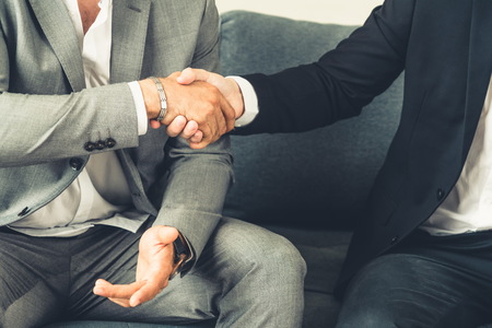 Businessman handshake with another businessman partner in modern workplace office. People corporate business deals concept.の写真素材