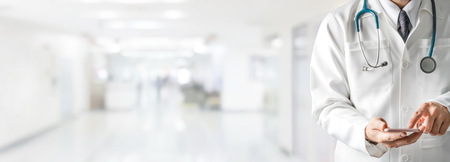 Male doctor using mobile phone at hospital. Medical healthcare and doctor service.の写真素材