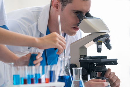 Group of scientists wearing lab coat working in laboratory while examining biochemistry sample in test tube and scientific instruments. Science technology research and development study concept.の写真素材