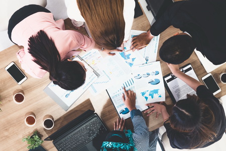 Top view of businessman executive in group meeting with other businessmen and businesswomen in modern office with laptop computer, coffee and document on table. People corporate business team concept.の写真素材