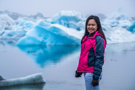 Woman traveler travels to Jokulsarlon beautiful glacial lagoon in Iceland. Jokulsarlon is a famous destination in Vatnajokull National Park, southeast Iceland, Europe. Cold winter ice nature.の写真素材