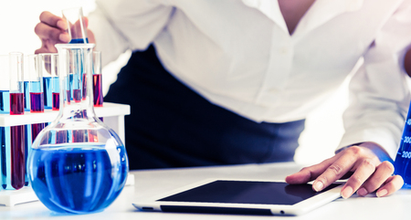 Woman scientist working in laboratory and examining biochemistry sample in test tube. Science technology research and development study concept.の写真素材