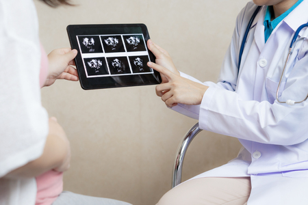 Happy pregnant woman visit gynecologist doctor at hospital or medical clinic for pregnancy consultant. Doctor examine pregnant belly for baby and mother healthcare check up. Gynecology concept.の写真素材