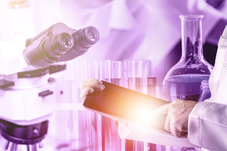 Research and development concept. Double exposure image of scientific and medical lab instrument, microscope, test tube and glass flask for microbiology and chemistry in laboratory for medicine study.の写真素材