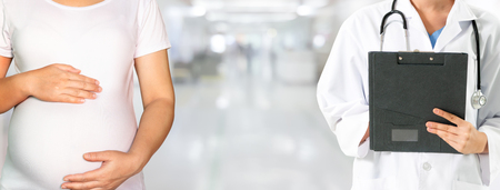 Happy pregnant woman visit gynecologist doctor at hospital or medical clinic for pregnancy consultant. Doctor examine pregnant belly for baby and mother healthcare check up. Gynecology concept.の写真素材