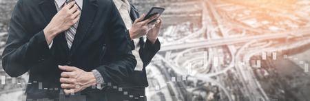 Double Exposure Image of Business Communication Network Technology Concept - Business people using smartphone or mobile phone device on modern cityscape background.の写真素材