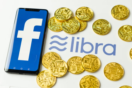 Bangkok, Thailand - July 2, 2019: Phone with Facebook logo on screen is placed on paper with Libra...
