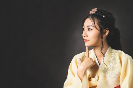 Korean woman wearing traditional korean dress (Hanbok) on black background in studio. Beautiful Korea culture.の写真素材